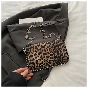 Close-up of leopard print handbag with silver bead rivets and fine metal chain strap