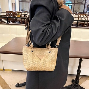Women's woven straw bucket bag in beige with faux leather handles and shoulder strap