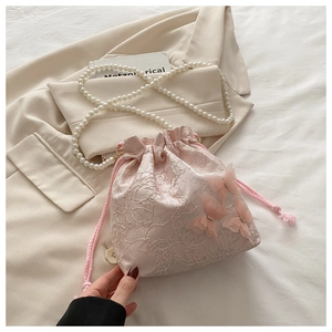 Detail of pink floral jacquard bucket bag with 3D organza butterflies and pearl strap
