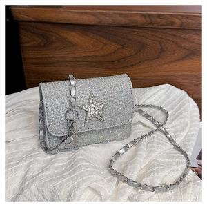 Dettaglio borsa di paillettes argento con stella di strass e tracolla a catena in metallo