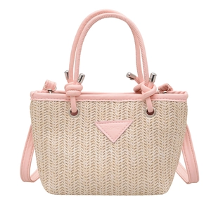 Fashionable woven straw bucket bag in pink and beige with a knotted handle and shoulder strap