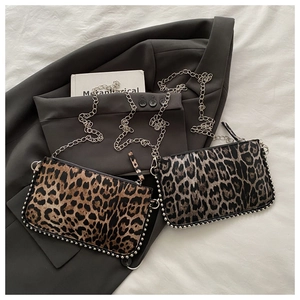 Détail de sacs à imprimé léopard avec clous argentés sur une veste de costume