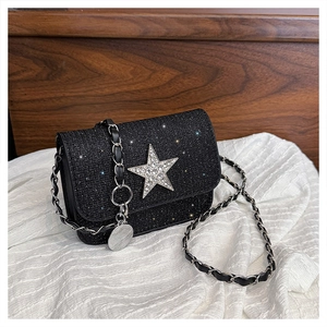 Dettaglio borsa a tracolla nera con paillettes e stella di strass argento con catena