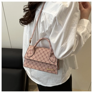 Détail du sac bandoulière vintage rose avec monogramme et logo sur un mannequin
