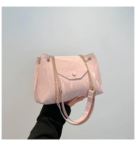 Detail der rosa Damen-Handtasche mit Lack-Faltenoptik, Goldkette und Magnetverschluss
