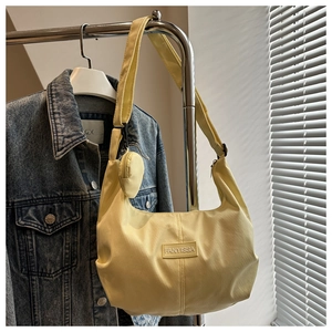 Détail du sac hobo en nylon jaune montrant la texture et le porte-monnaie rond