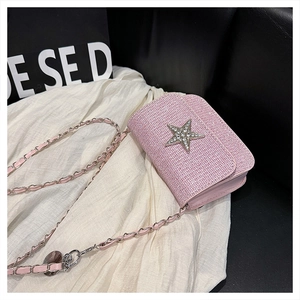 Macro della trama in tessuto rosa e del ciondolo a stella con strass sulla borsa