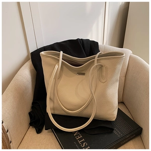 Vue détaillée du sac cabas en cuir grainé crème avec plaque logo argentée élégante