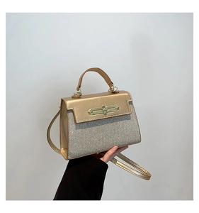 Close-up of champagne gold sequined handbag with metallic clasp and adjustable strap