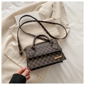 Détail du motif à carreaux rétro marron et du logo doré sur le sac à main chic