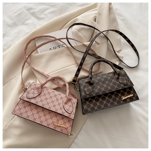 Détails du motif monogramme vintage et logo doré sur le sac en cuir synthétique
