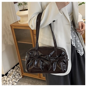 Details der dunkelbraunen, glänzenden Ledertasche mit Schleifentaschen im Retro-Stil