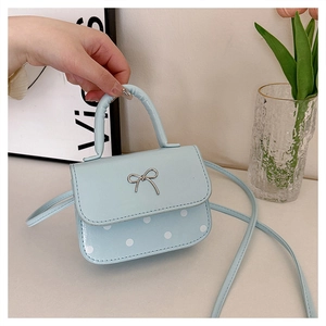 Détail du mini sac bleu clair à pois avec nœud argenté et poignée supérieure