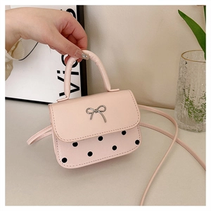 Détail du mini sac rose avec fermoir papillon métallique et motifs à pois