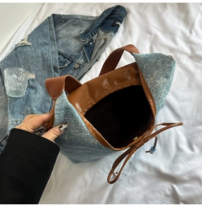 Close-up of light blue denim tote bag featuring studded rhinestones and drawstring closure