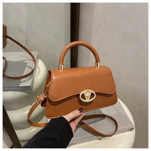 Détail d'un sac trapèze en cuir marron avec boucle en V et poignée ronde élégante