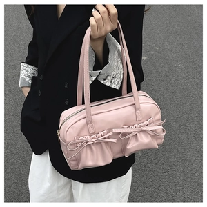 Detailansicht der rosa Schultertasche mit dekorativen Schleifen und gefalteter Tasche