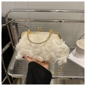 Detailed close-up of cream white shell evening bag with 3D organza roses and metal clasp