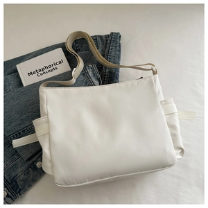 Détail du sac cabas blanc en nylon avec bandoulière réglable et poches latérales pratiques