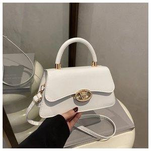 Détail du sac à main en cuir blanc avec boucle dorée en V et poignée supérieure élégante
