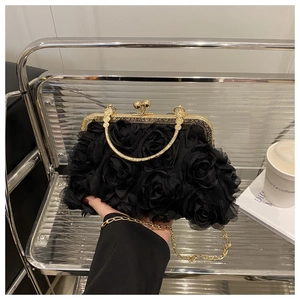 Close-up of the black 3D rose petal evening bag with a metallic gold top handle and chain