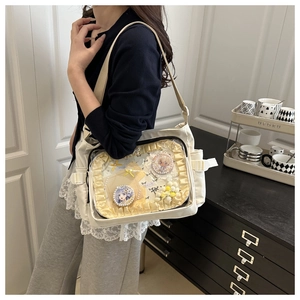 Détail d'un sac Ita en toile blanche avec des volants jaunes et une fenêtre transparente