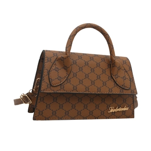 Sac bandoulière vintage à monogramme marron avec logo doré sur fond blanc pur