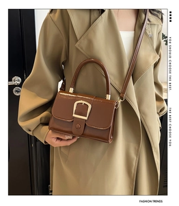 Dettaglio della borsa in pelle marrone con fibbia in metallo dorato e design vintage