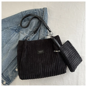 Detail of black corduroy tote bag set with chain strap and matching zipper pouch