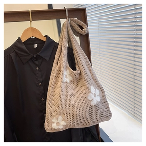 Detailed macro view of hand-crocheted hollow floral pattern on a beige tote bag