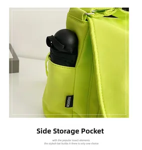 Détail de la poche latérale de ce sac bandoulière en nylon contenant un parapluie pliant noir