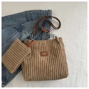 Detailed view of brown corduroy tote bag and small zipper pouch with metal chain strap