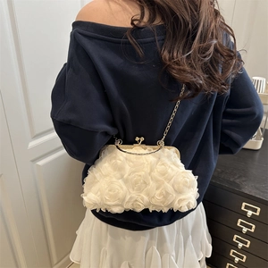 Elegant white 3D floral evening bag with gold chain strap worn by a model