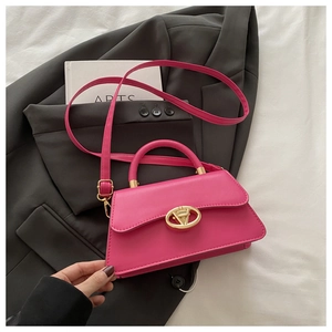 Détail macro du sac en similicuir magenta avec fermoir rotatif élégant en métal doré