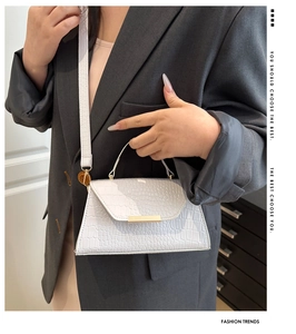 Détail du sac à bandoulière blanc à motif crocodile avec boucle dorée élégante