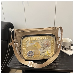 Détail du sac ita en toile avec une grande fenêtre transparente et décoration de badges