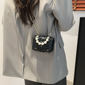 Mini black crossbody bag with heart quilting and faux pearl handle for a modern look
