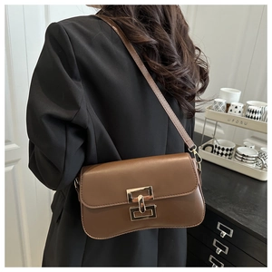 Detailed view of a brown leather shoulder bag featuring a classic gold rectangular lock