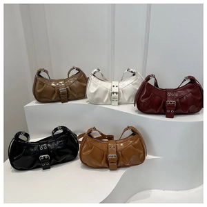 Detail of five glossy PU leather underarm bags with pleated design and silver buckles