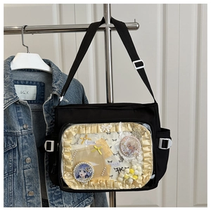 Détail d'un sac Ita noir avec fenêtre PVC transparente, dentelle jaune et badges anime