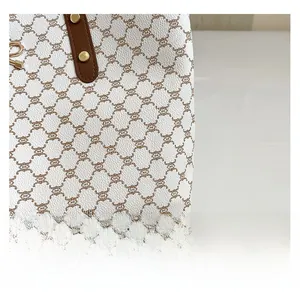 Gros plan du sac cabas blanc avec motif de chaîne marron et texture de cuir grainé