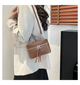 Détail du sac boîte tissé marron caramel avec fermetures éclair et poignée supérieure