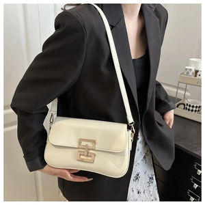 Detail of cream white leather shoulder bag with a unique gold geometric metal buckle