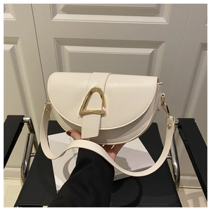 Close-up of a cream-colored saddle bag with a gold buckle on a black chair