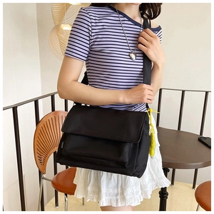 Modèle portant une grande sacoche en nylon noir pour les trajets quotidiens