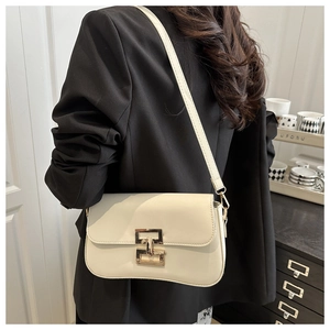 Minimalist beige crossbody bag with gold metal buckle shown on shoulder for daily wear