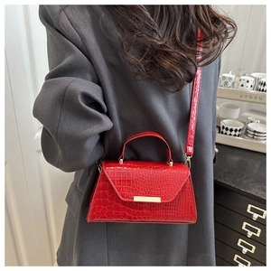 Sac à main rouge motif crocodile avec boucle dorée en vue mode lifestyle décontractée