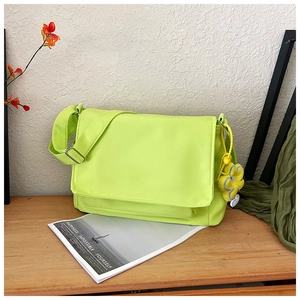 Détail du sac bandoulière en nylon vert néon avec charme de tournesol sur bois