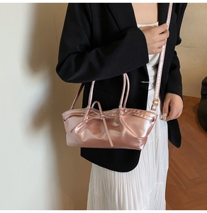 Detail of pink metallic tote bag featuring elegant bow design and adjustable shoulder strap