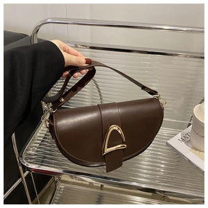 Detail view of deep brown semi-moon saddle bag with a golden metal buckle and leather strap